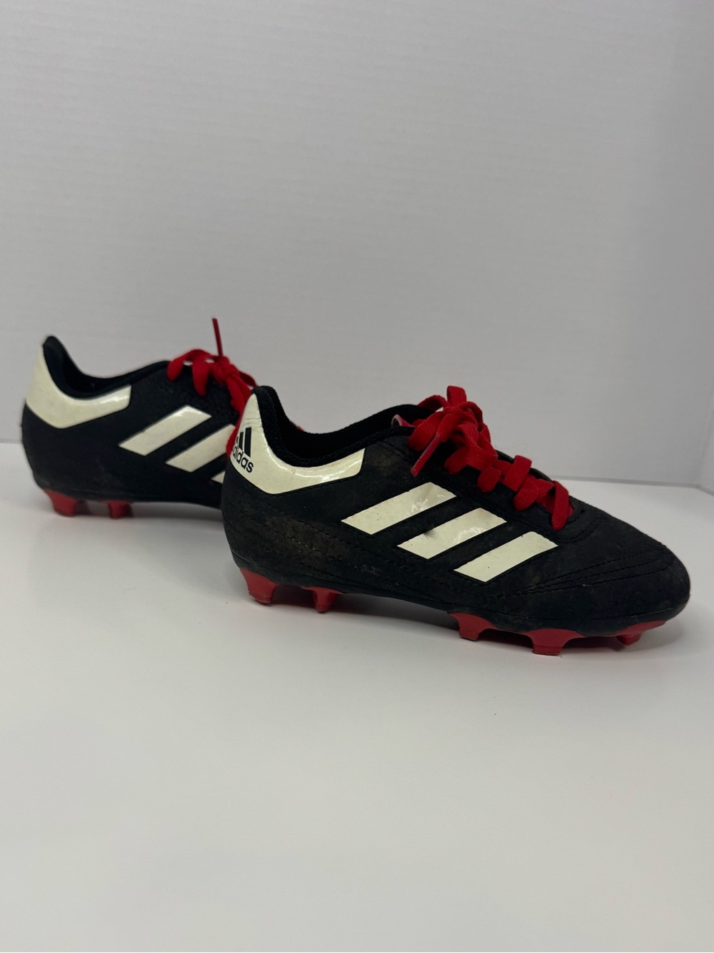 Adidas Black Soccer Cleats with White Stripes and Red Laces